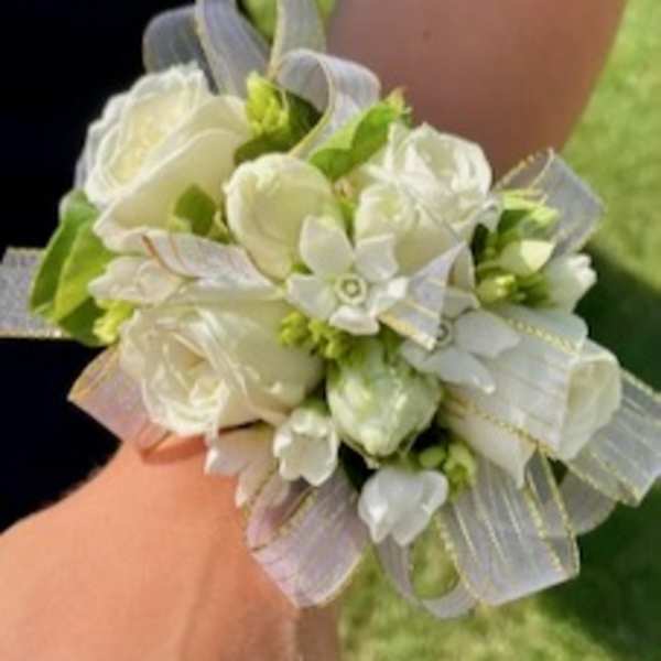 White rose corsage with ribbon on a wrist