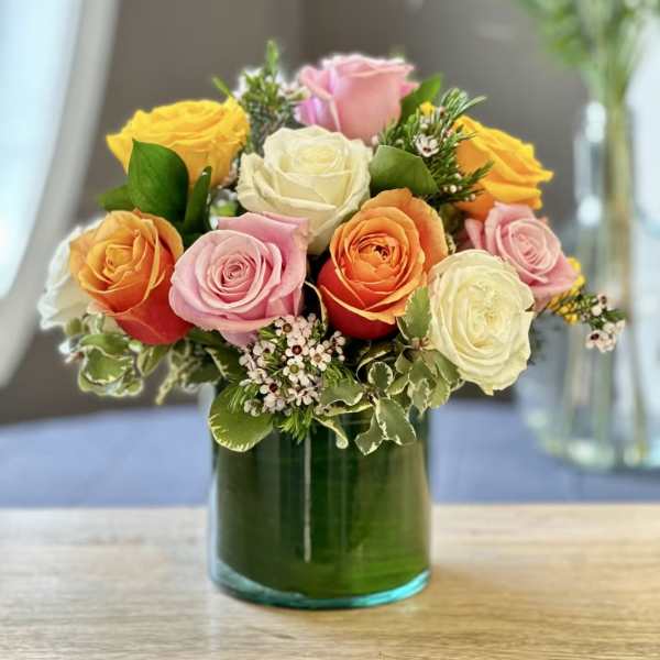 Mixed roses arranged in a green glass vase