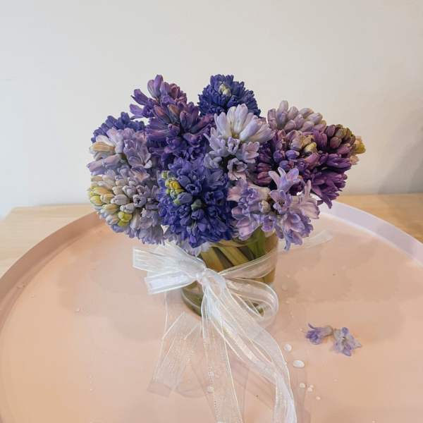 Purple and lavender flower bouquet tied with a white ribbon