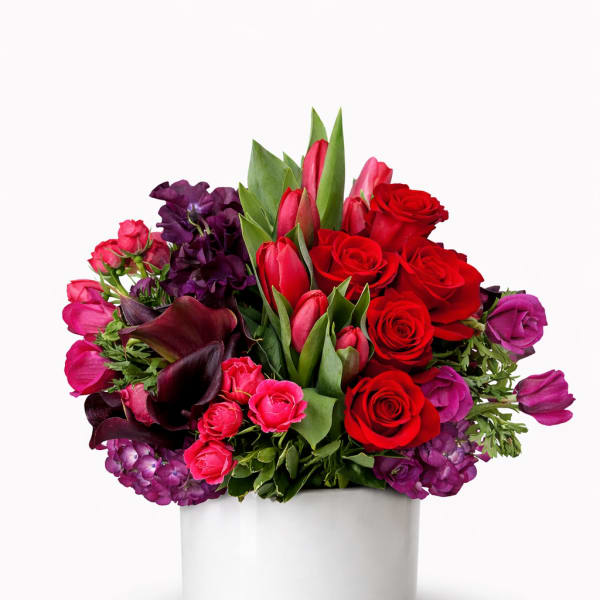 Red and purple bouquet in a white round box