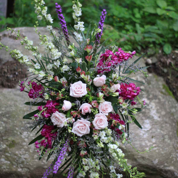 Tall floral spray with pale pink roses and purple and white blooms