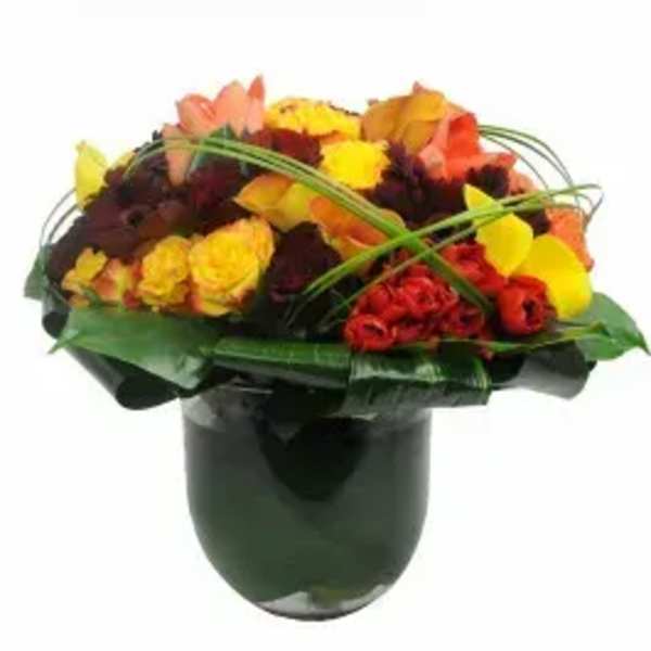 Mixed bouquet of yellow, orange, and red flowers in a dark vase