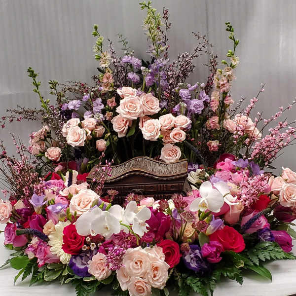 Large floral arrangement with pink and purple roses and white orchids