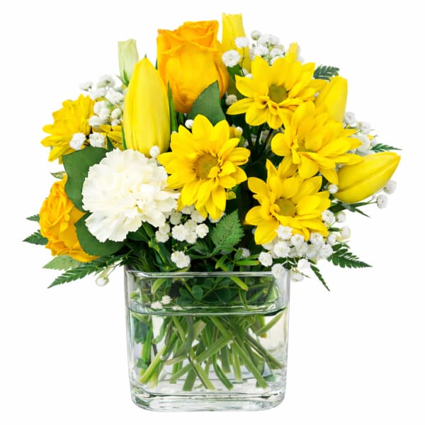 Yellow roses and daisies in a clear glass vase