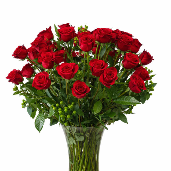 Red roses arranged in a clear glass vase