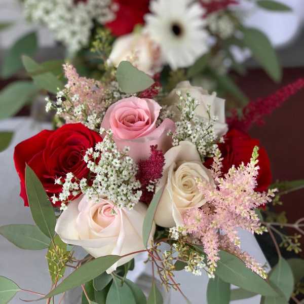 Bouquet of red, pink, and white roses with airy filler flowers