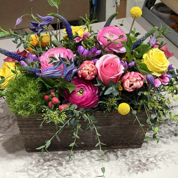 Colorful mixed flower arrangement in a rectangular wooden container
