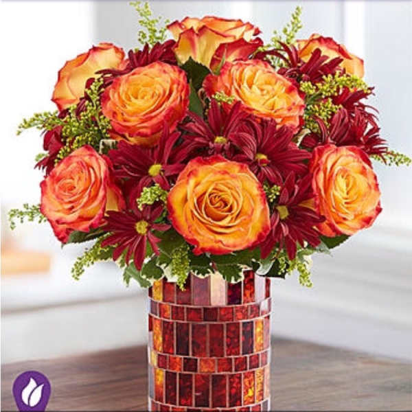 Bouquet of orange roses and burgundy daisies in a mosaic vase
