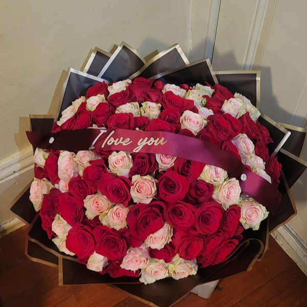 Large bouquet of red and pale pink roses with an "I love you" ribbon