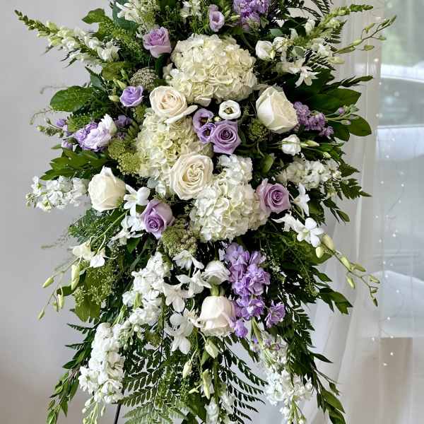 Large standing floral spray with white, lavender, and cream blooms
