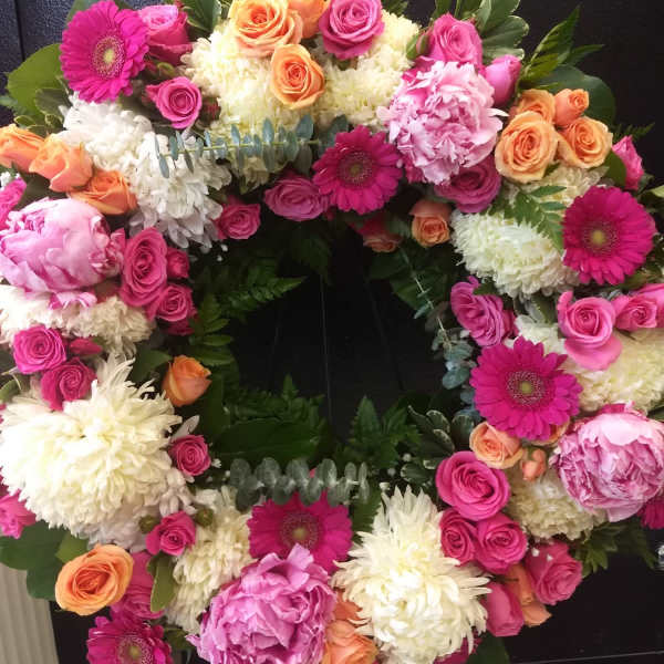 Heart-shaped floral wreath with pink, peach, and white flowers