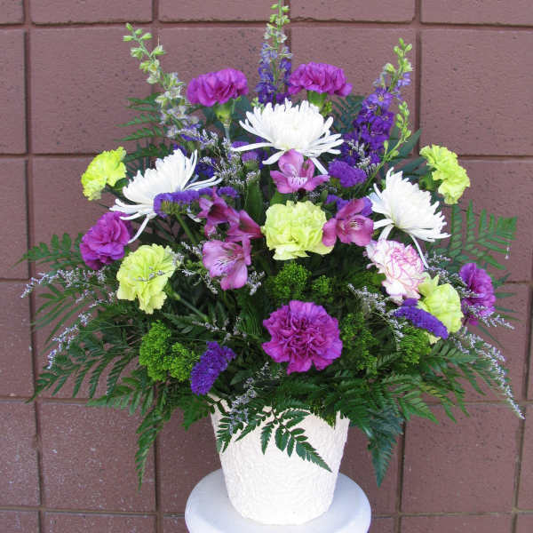 Colorful mixed flower arrangement in a white pot