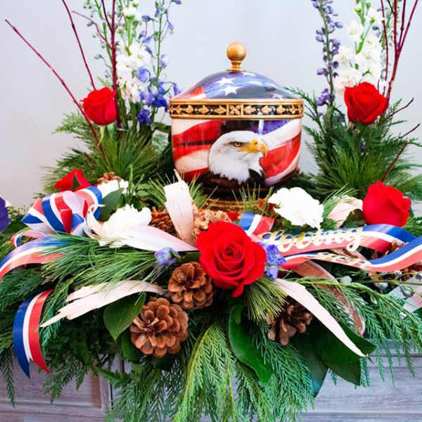 Red roses and patriotic ribbons around an eagle urn centerpiece