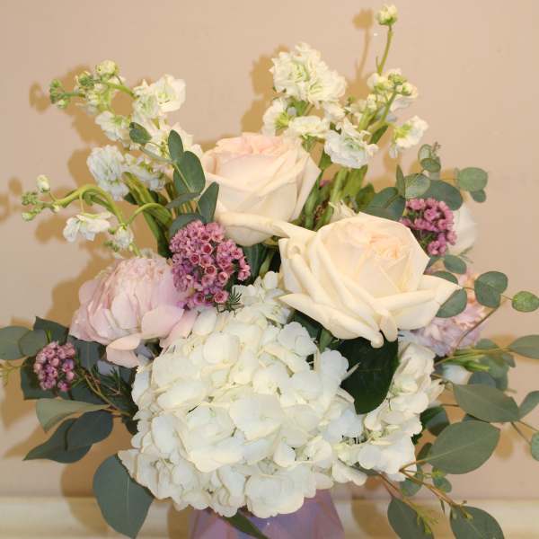 Bouquet of white and blush roses with hydrangea in a pink vase