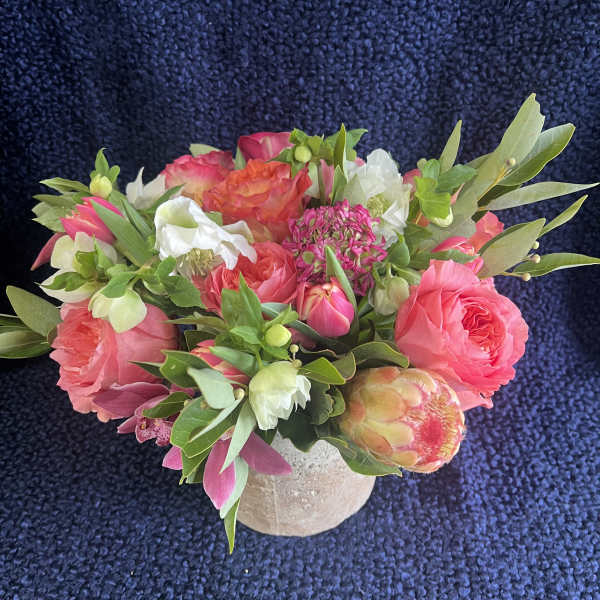 Pink and white mixed bouquet in a small beige vase