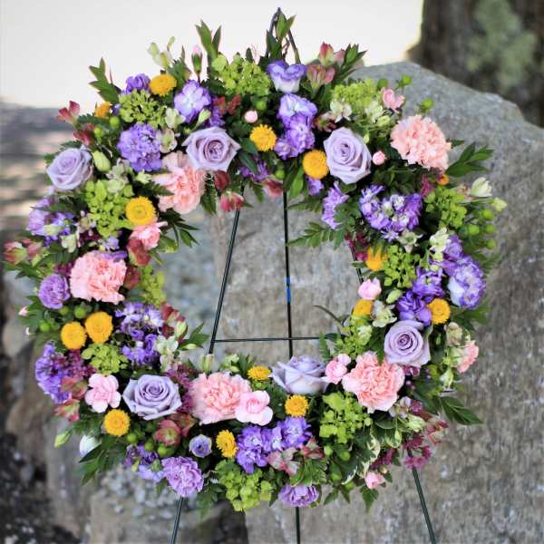 Circular floral wreath with lavender, pink, yellow, and green blooms