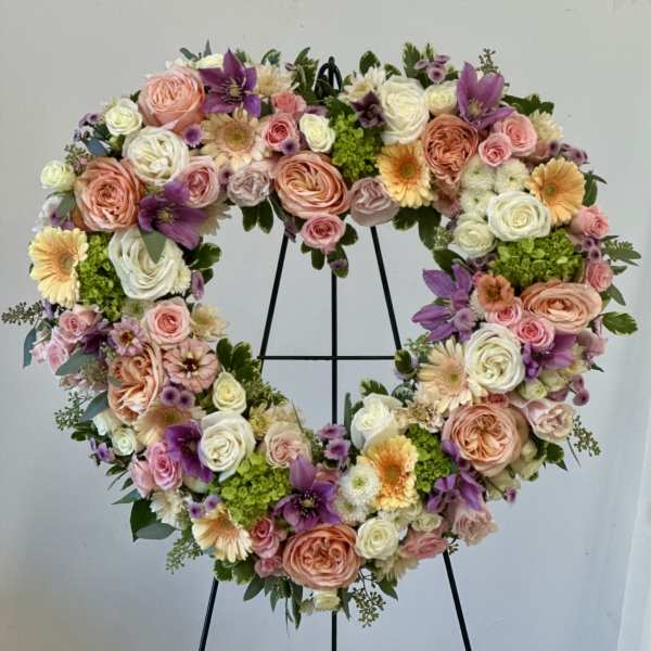 Heart-shaped floral wreath with pink, white, purple, and peach blooms