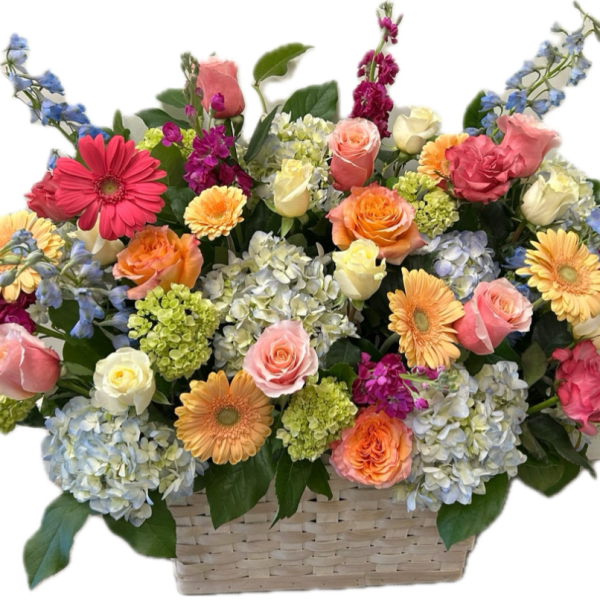Mixed bouquet in a woven basket with roses, gerbera daisies, and hydrangeas