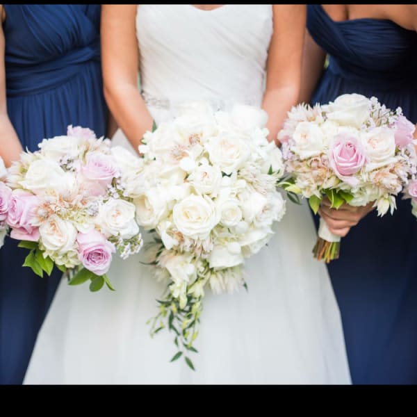 Bride and bridesmaids holding white and pink rose bouquets