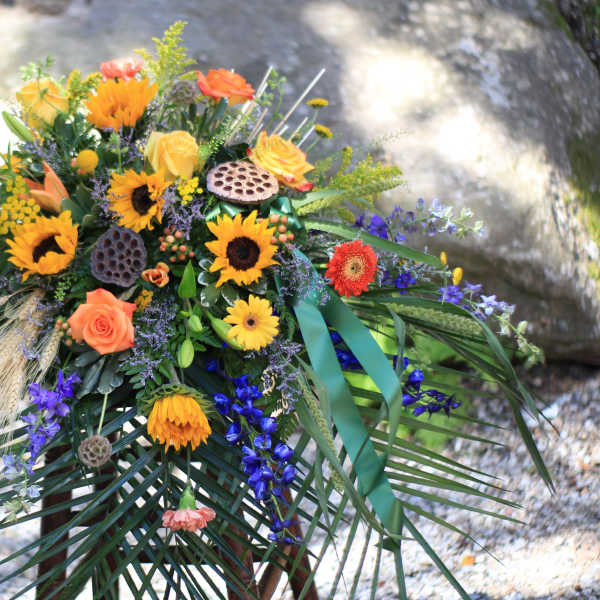 Colorful floral spray with sunflowers, roses, and blue flowers