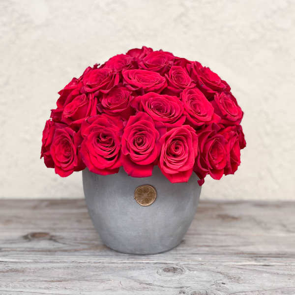 Round bouquet of bright pink roses in a gray vase