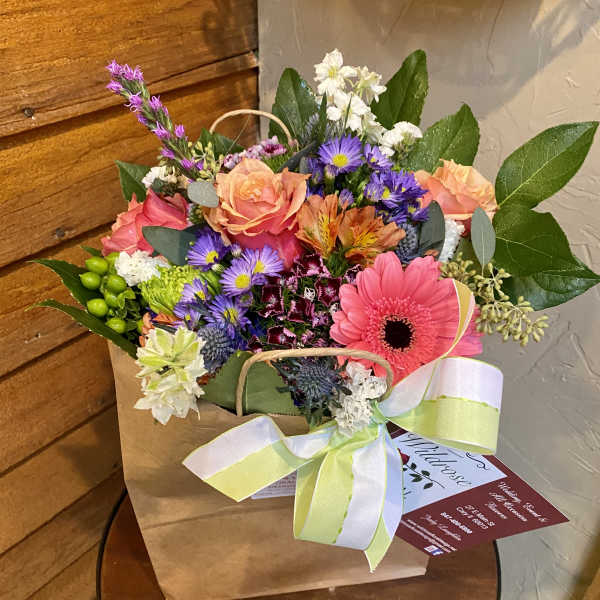 Mixed bouquet in a paper bag with a ribbon bow