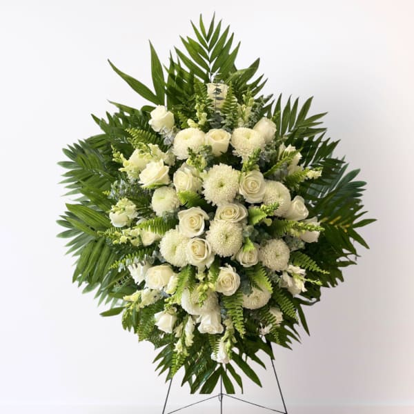 White floral standing spray with roses and mums on an easel
