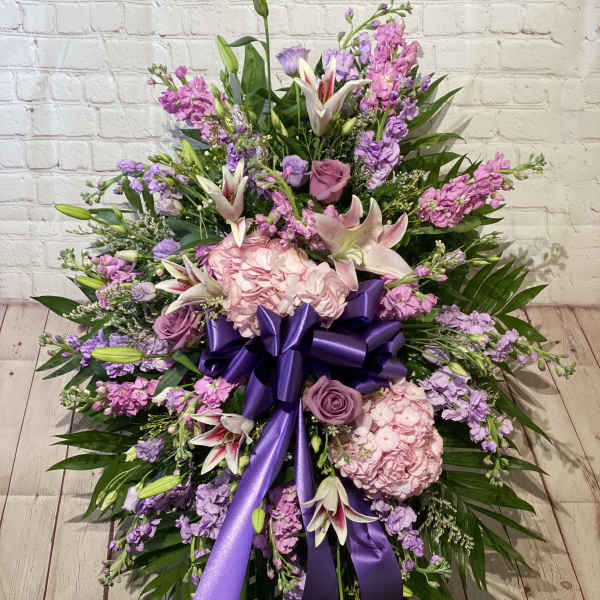 Large pink and purple floral spray with a purple ribbon bow