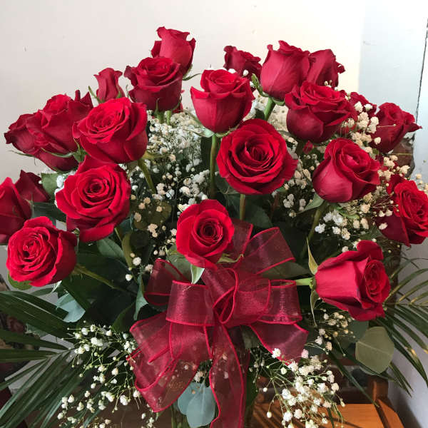 Bouquet of red roses with baby's breath in a glass vase