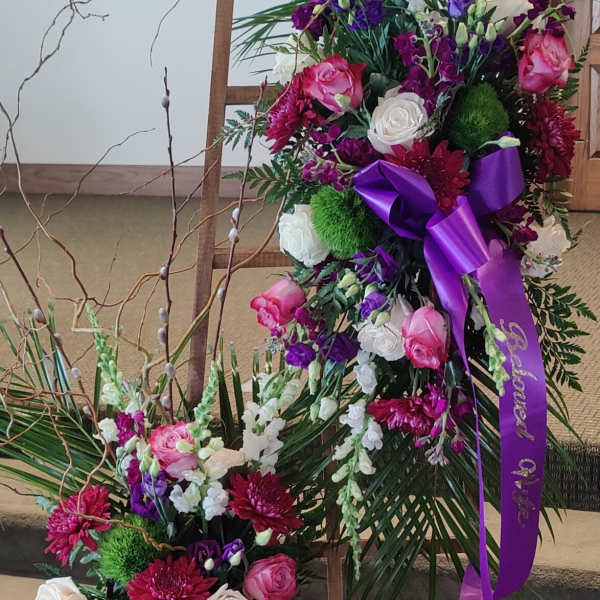 Two floral standing sprays with pink, white, and purple flowers on easels