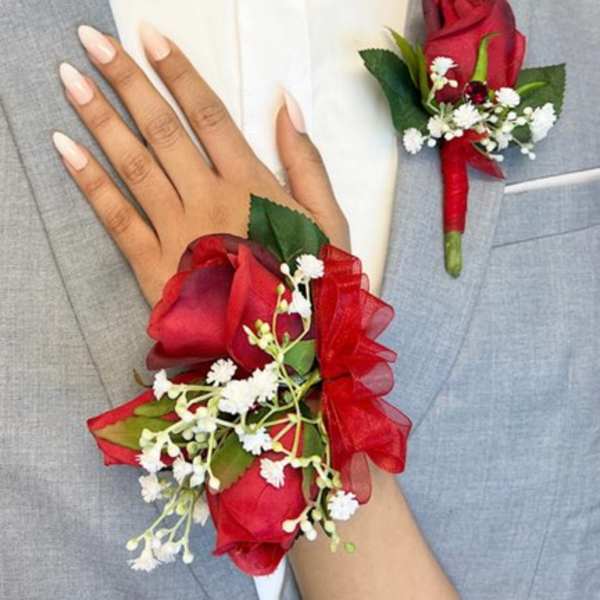 Red rose boutonniere and wrist corsage on a gray suit