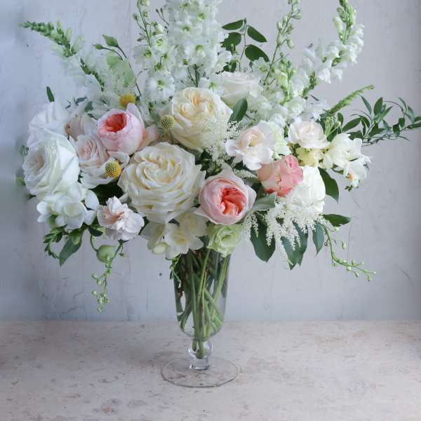 White and blush floral arrangement in a clear glass vase