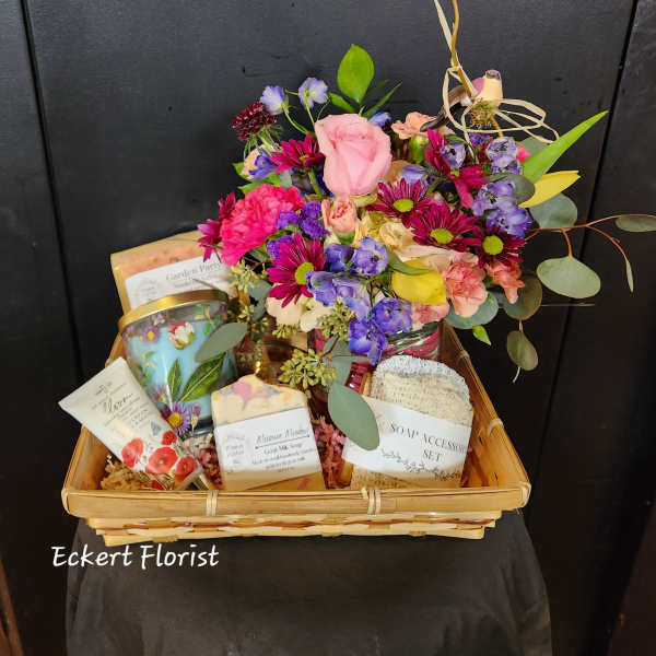 Gift basket with a mixed flower arrangement and bath products