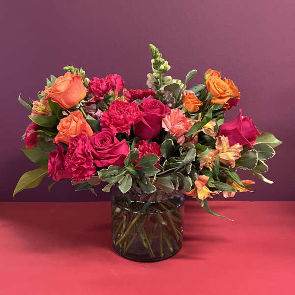 Bouquet of pink and orange flowers in a glass vase