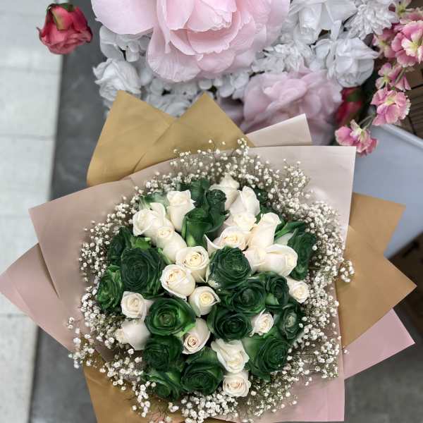 Bouquet of green and white roses wrapped in pastel paper
