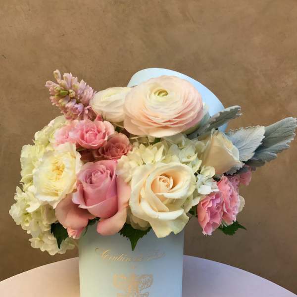 Pastel bouquet of roses, ranunculus, and hydrangeas in a light blue box