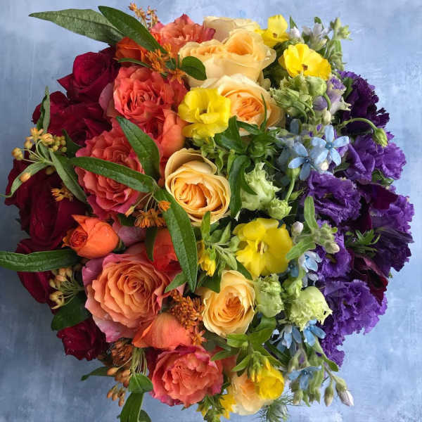 Colorful bouquet of roses, yellow blooms, and purple flowers