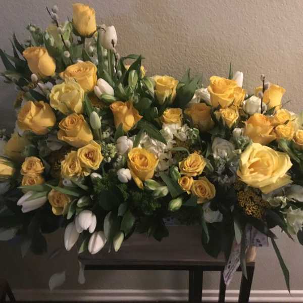 Large yellow rose arrangement with white flowers and greenery