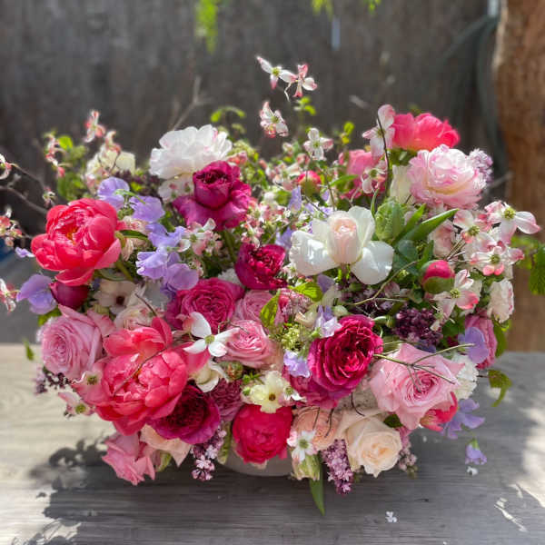 Large bouquet of pink, white, and lavender flowers in a low container