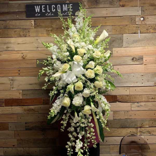 Tall white floral arrangement with roses and calla lilies