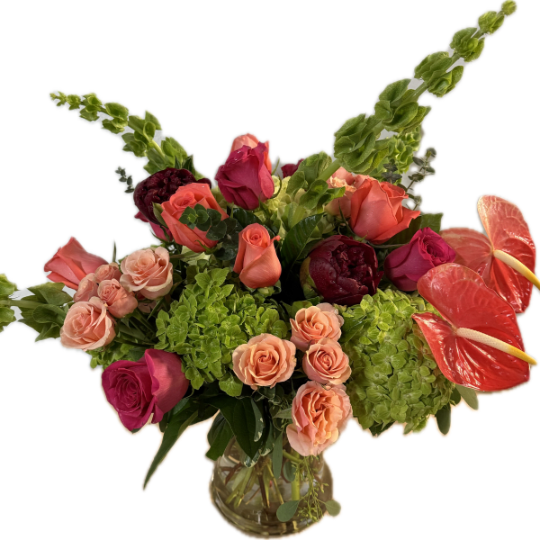 Mixed bouquet of roses, hydrangeas, and anthuriums in a glass vase
