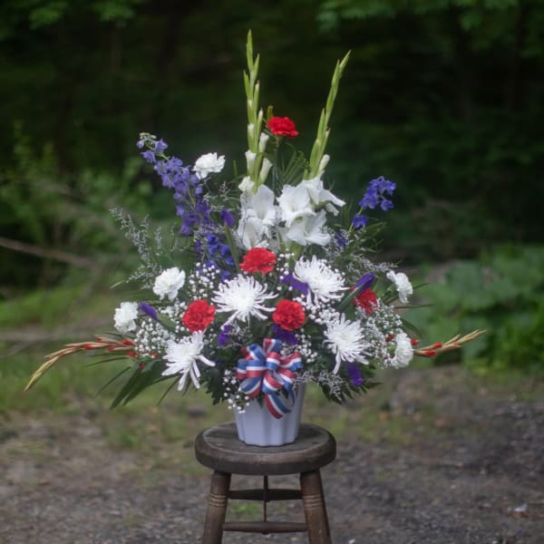 Tall red, white, and purple floral arrangement in a white vase