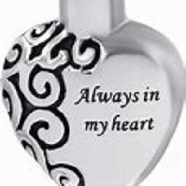 Heart-shaped silver pendant with black swirl design and text