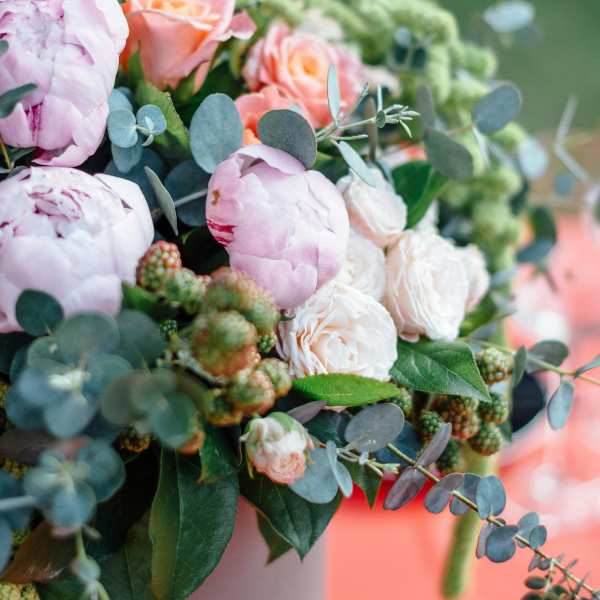 Pink and peach roses with pale peonies in a vase