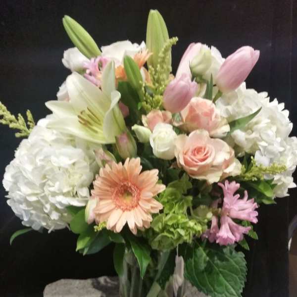 Mixed bouquet in a gold vase with lilies, roses, hydrangeas, and gerbera daisies