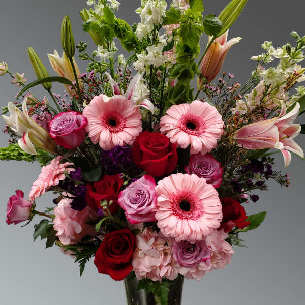 Mixed bouquet of pink and red flowers in a glass vase