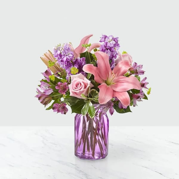 Pink lilies and roses in a purple glass vase