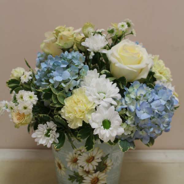 Blue and white flower arrangement in a decorative ceramic pot