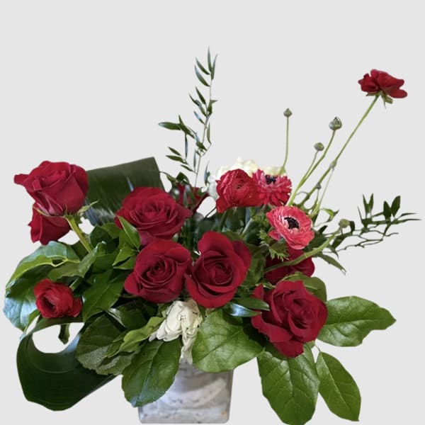 Red roses and pink gerbera daisies in a clear vase
