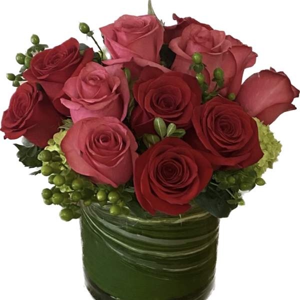 Bouquet of red and pink roses in a green glass vase